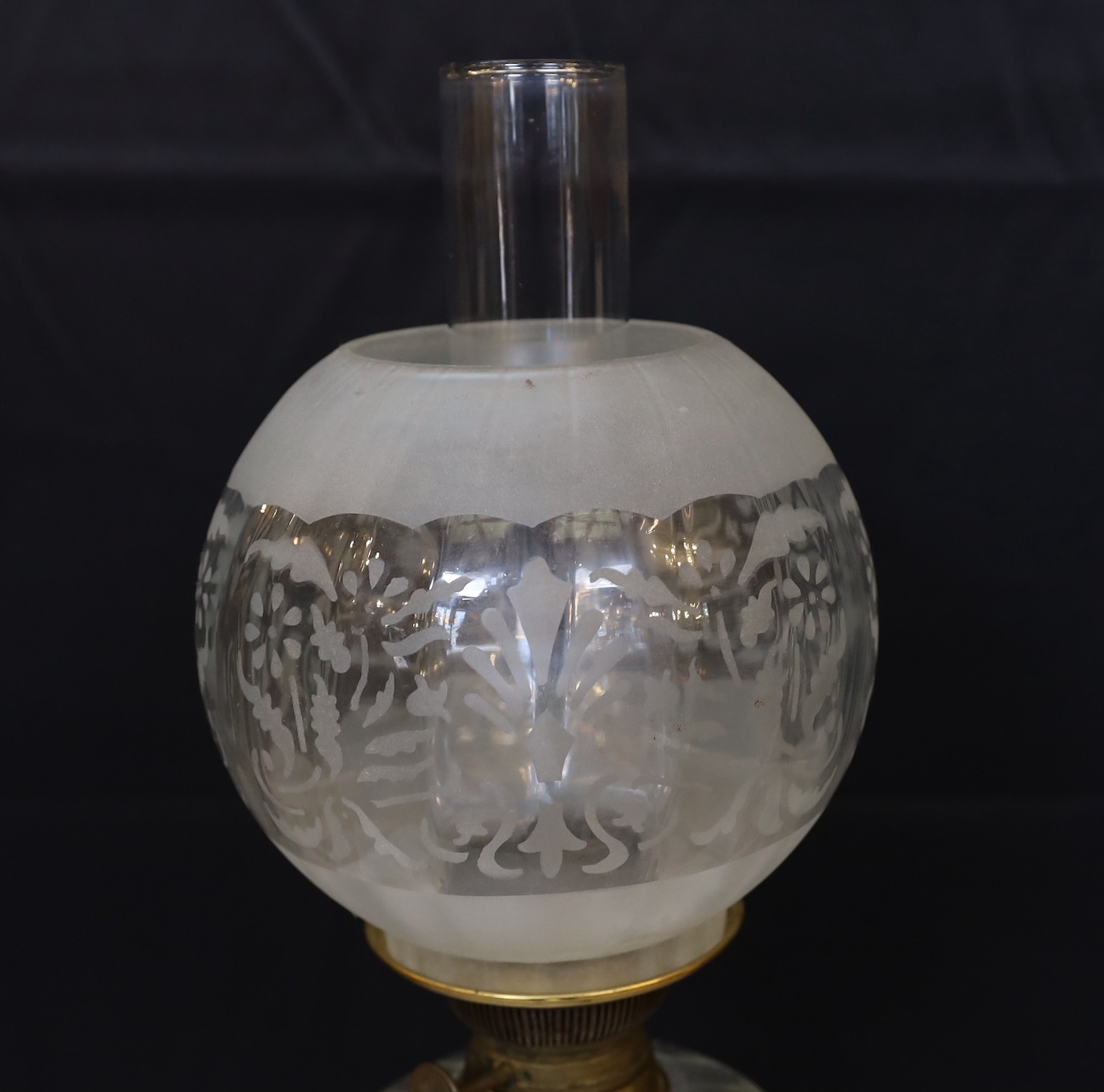 An Edwardian brass oil lamp with lobed glass reservoir, frosted globe and flue, height overall 74cm